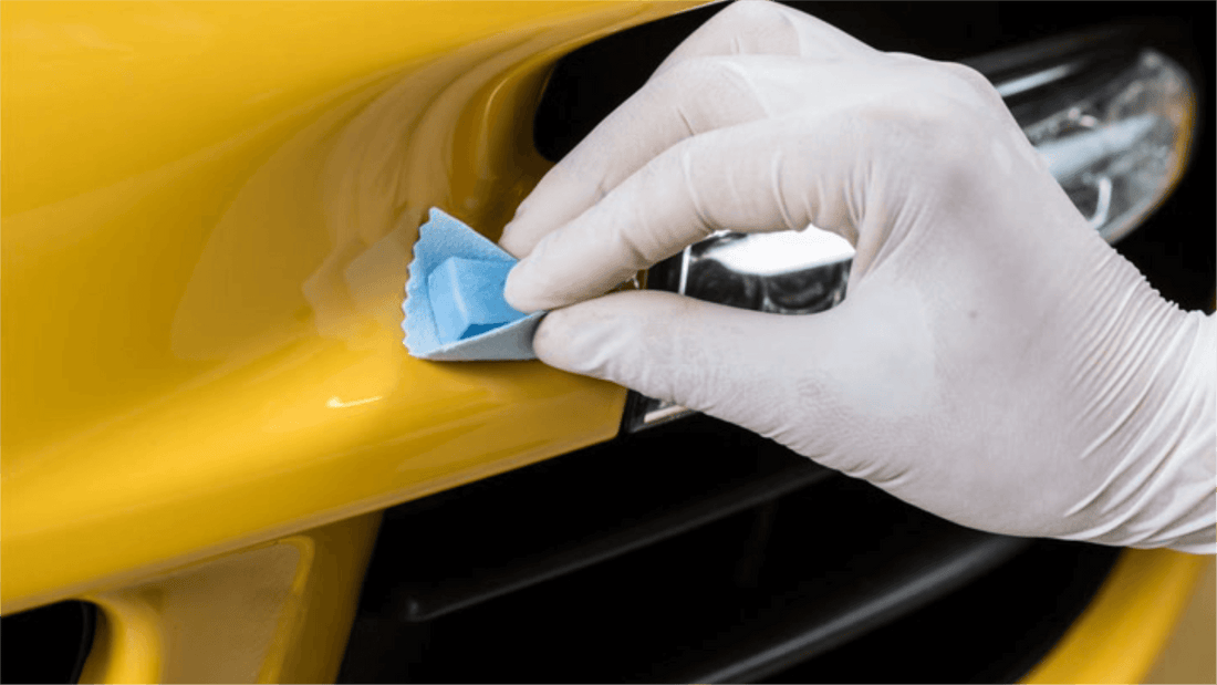 Ein gelbes Auto wird von Hand geschliffen