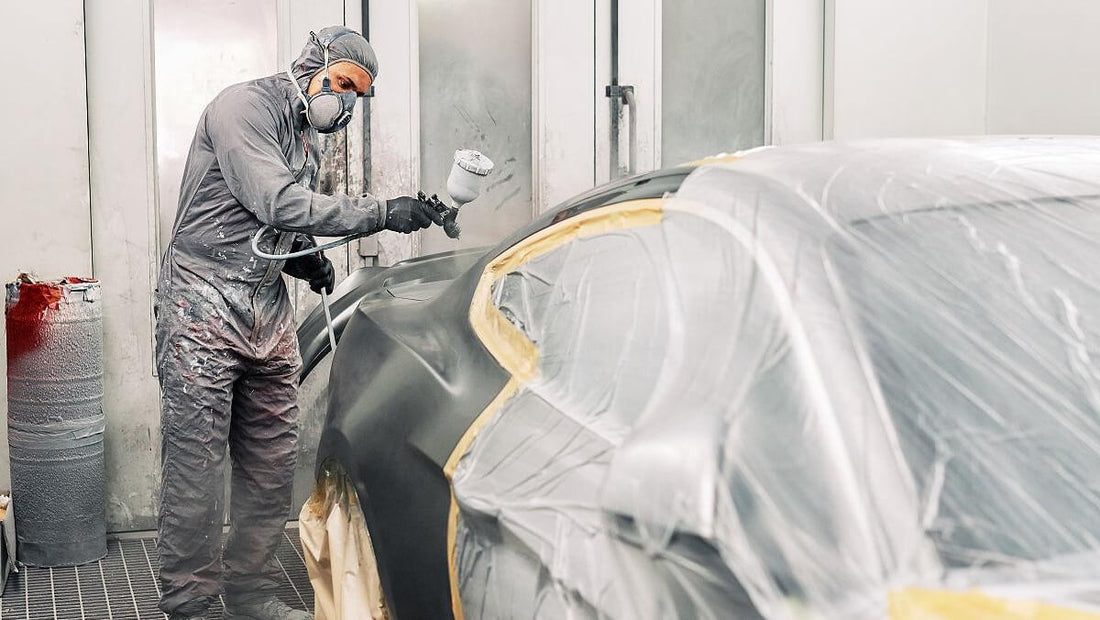 A painter is painting the car