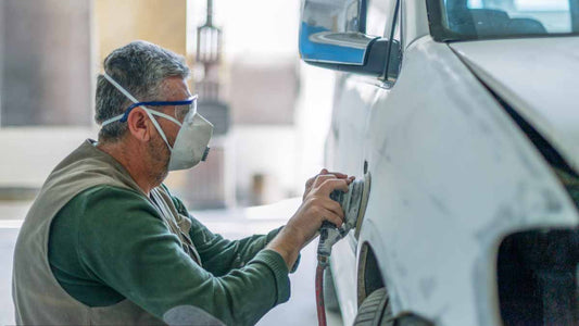 Männer mit Gasmasken polieren Autos