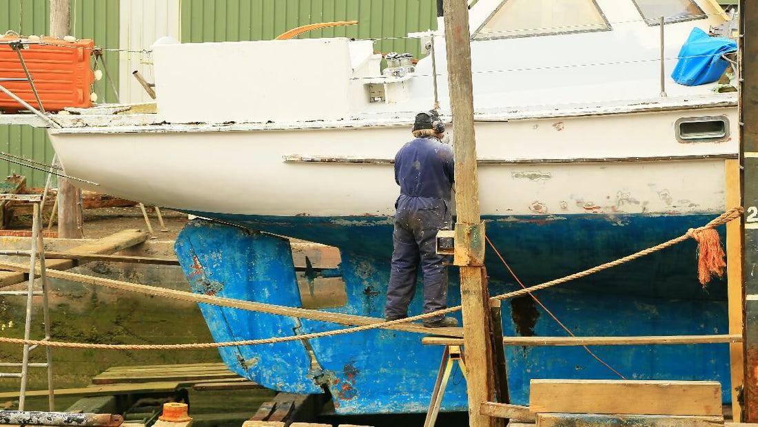 Ein Mann streicht das Boot